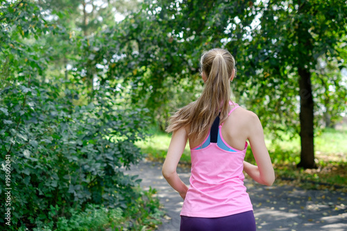 Fototapeta Naklejka Na Ścianę i Meble -  Attractive young woman jogging on park trail. healthy lifestyle concept