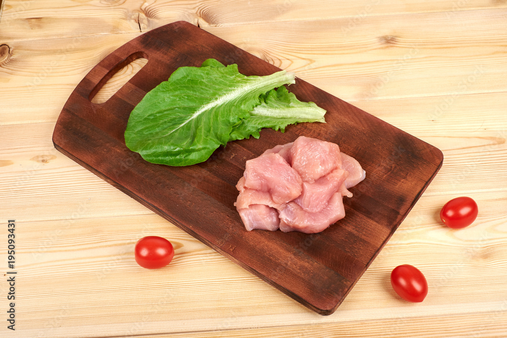Raw turkey fillet pieces on a cutting board wooden background Raw turkey fillet pieces on a cutting board wooden background