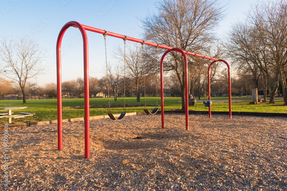 swingset painted red with two types of seats