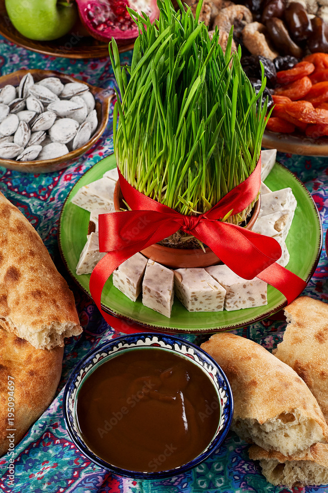 Traditional Azerbaijan sweet cuisine of holiday Nowruz. National dessert called Sumalak. Sprouted seeds with red ribbon