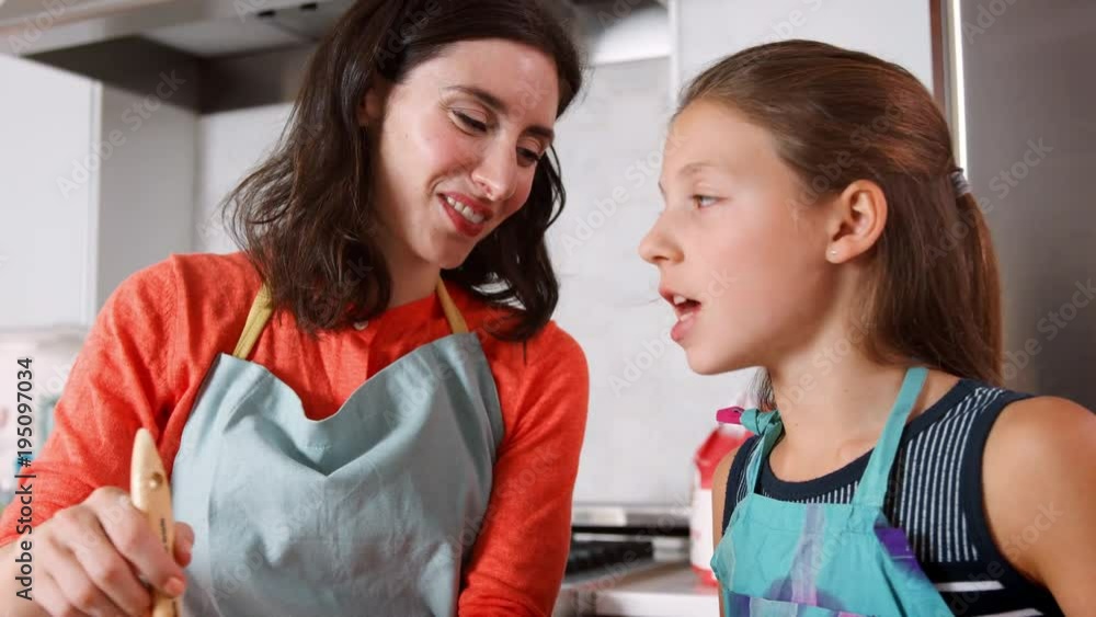 Girl and mother glazing dough for challah bread, close up