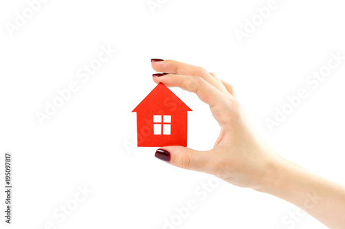 The hand holds the red house. House in hands. Close up. Isolated on a white background