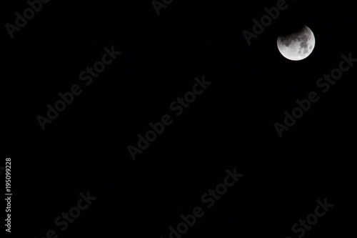 Partial Eclipse of moon, located top right of photo