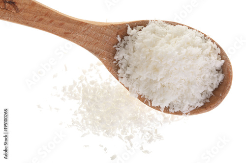 Heap of coconut flakes in wooden spoon isolated on white background