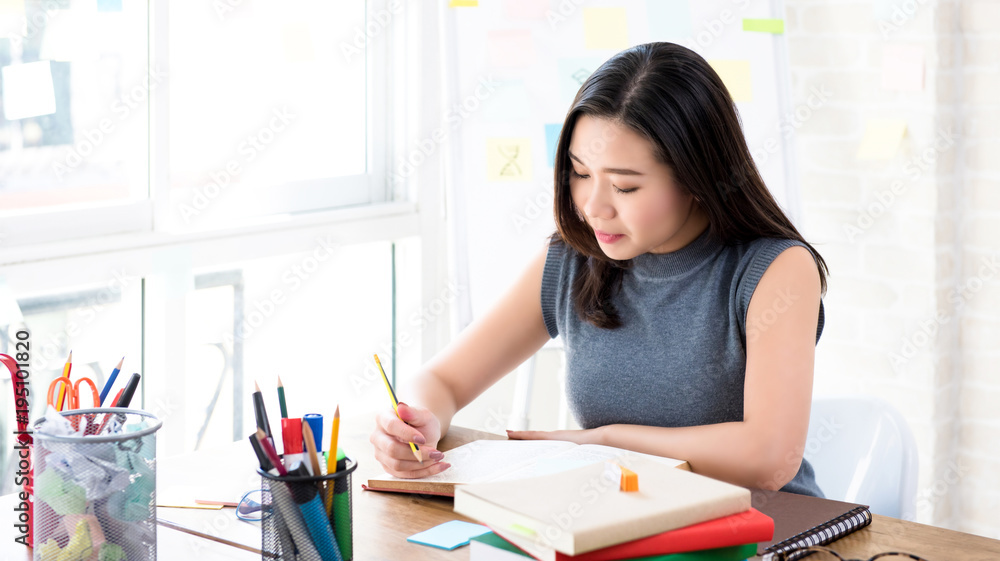 Asian female college student reading book at the table Asian female college student reading book at the table