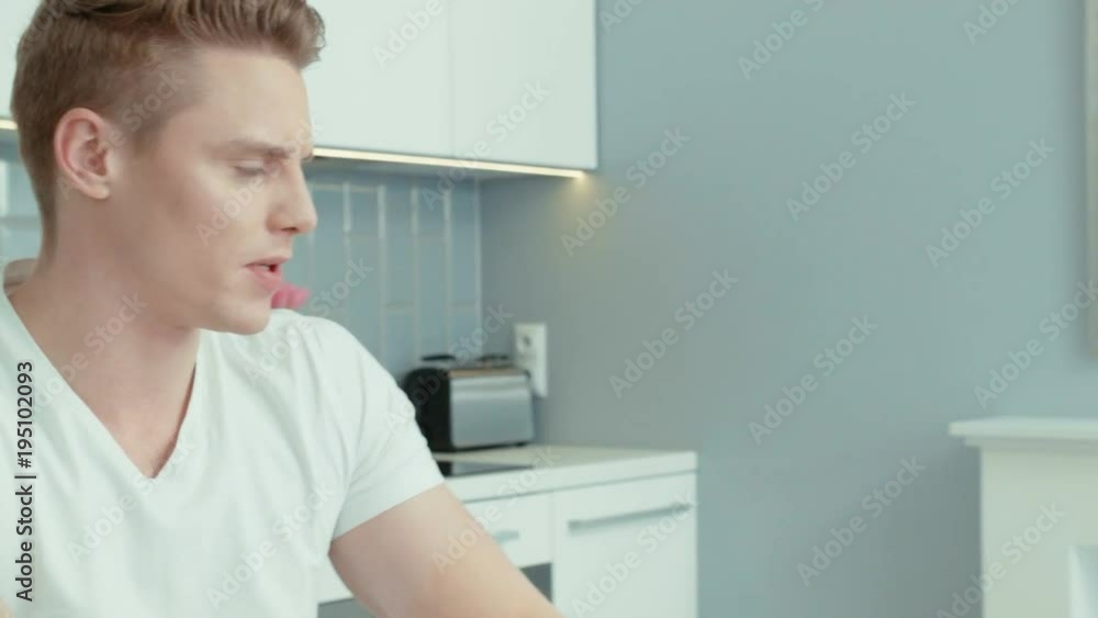 Young couple sitting at a table arguing. Woman is angry because man is not listening to her, he is watching his phone. Young couple sitting at a table arguing. Woman is angry because man is not listening to her, he is watching his phone.