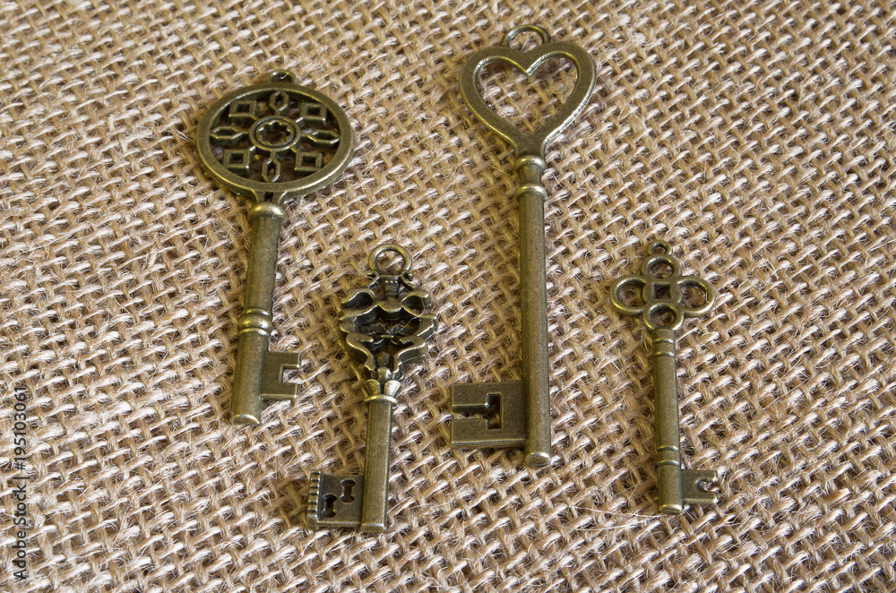 Four bronze ancient keys on burlap. Four bronze ancient keys on burlap.