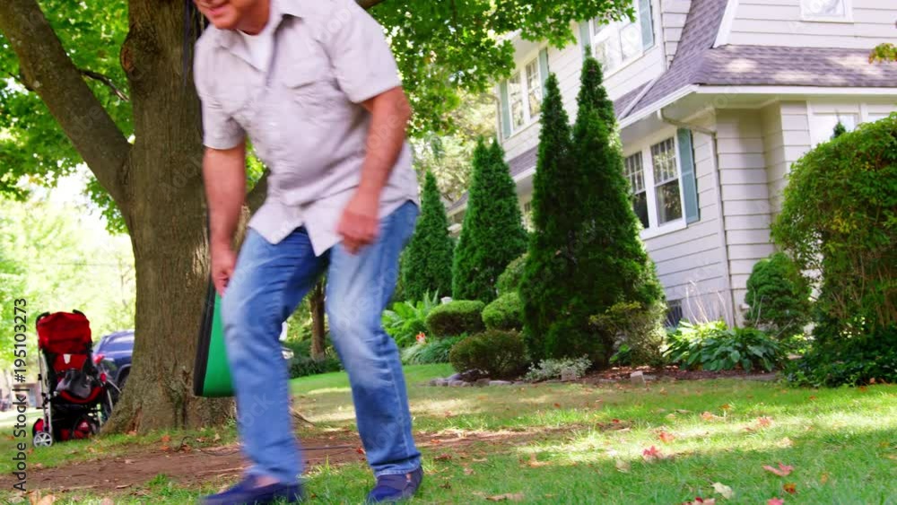 Grandfather Playing Soccer In Garden With Grandson Grandfather Playing Soccer In Garden With Grandson