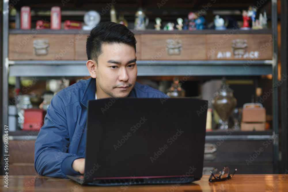 Asian man working with laptop in cafe, work concept.
