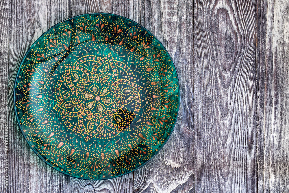 Top view green painted plate on wooden surface Top view green painted plate on wooden surface
