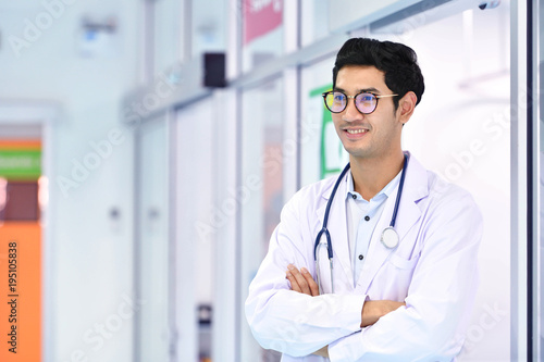 Smiling Asian medical doctor with stethoscope in hospital with copy space