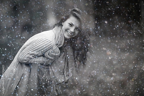 Winter portrait of young girl with snowflakes in the air