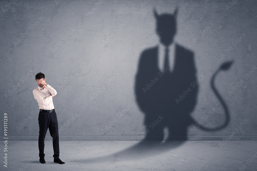Fototapeta premium Business man looking at his own devil demon shadow concept