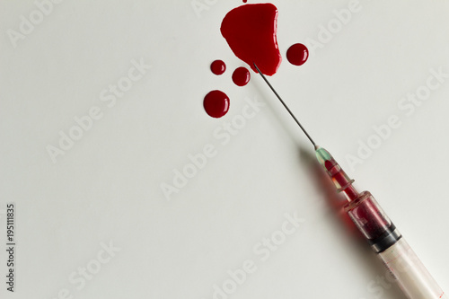 Syringe with blood and blood splatters closeup and isolated on white background