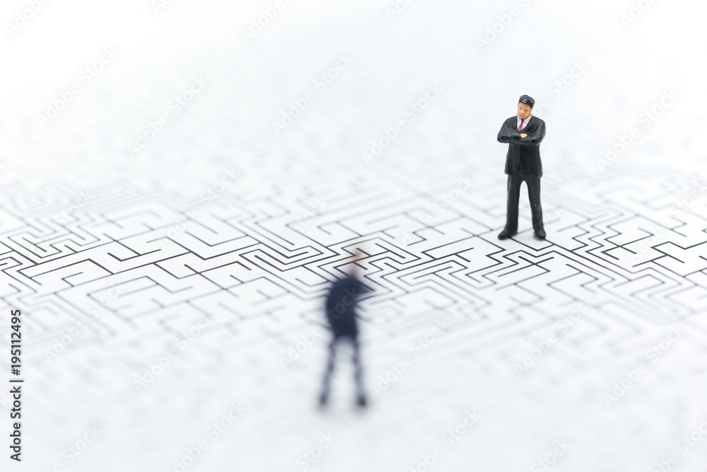 Miniature people: Businessman standing on start point of maze using as background business concept. Miniature people: Businessman standing on start point of maze using as background business concept.