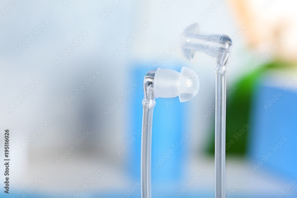 Hearing aids on blurred background, closeup Hearing aids on blurred background, closeup