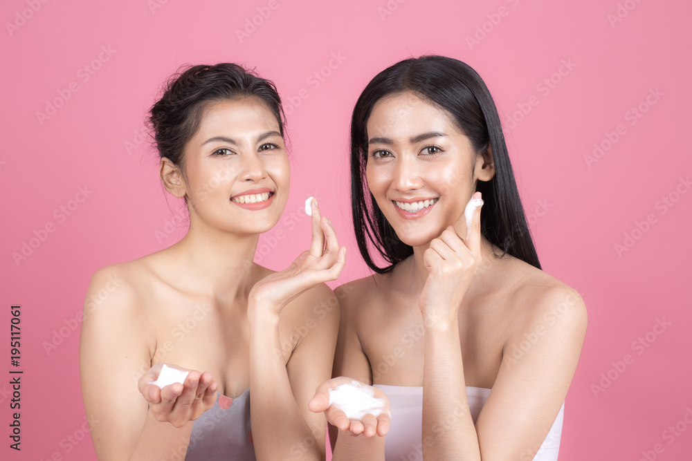 Woman show her a face skin with foam on a pink background Woman show her a face skin with foam on a pink background