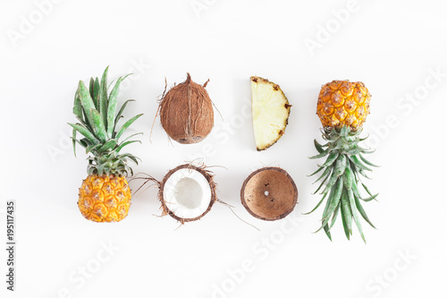 Fruit background. Pineapples and coconuts on white background. Summer fruits. Flat lay  top view