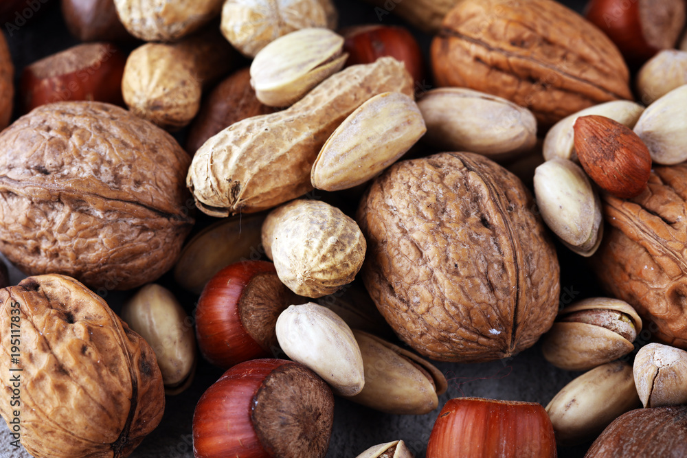 mixed nuts on grey background. Healthy food and snack. Walnut, pecan, almonds, hazelnuts and cashews. mixed nuts on grey background. Healthy food and snack. Walnut, pecan, almonds, hazelnuts and cashews.