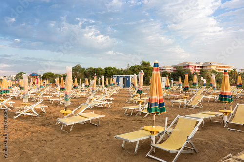 Rows of umbrellas and sun loungers, early morning on the beach, Bibione, Italy 
