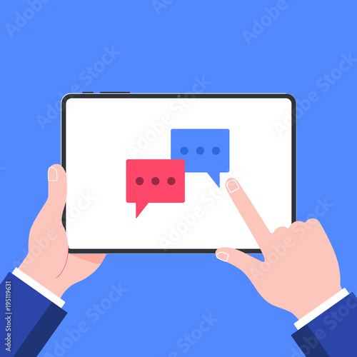Hand holding black tablet device isolated on blue background. Pad tablet on human hands with chat bubbles and index finger pointer touch the screen flat design vector illustration. Symbol of chatting.