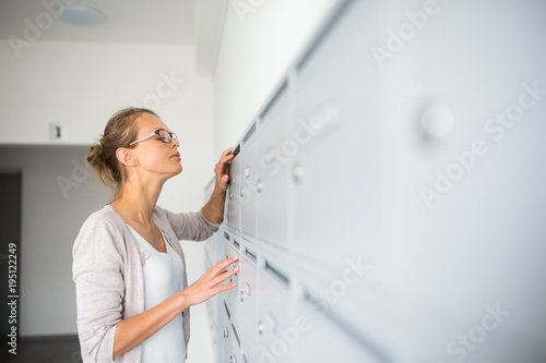 Pretty, young woman checking her mailbox for new letters © lightpoet