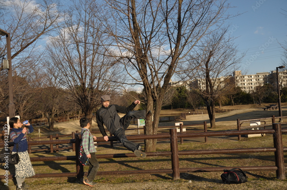 柵を飛び越える　超える　ジャンプ　父　家族　子供たち　秋の公園