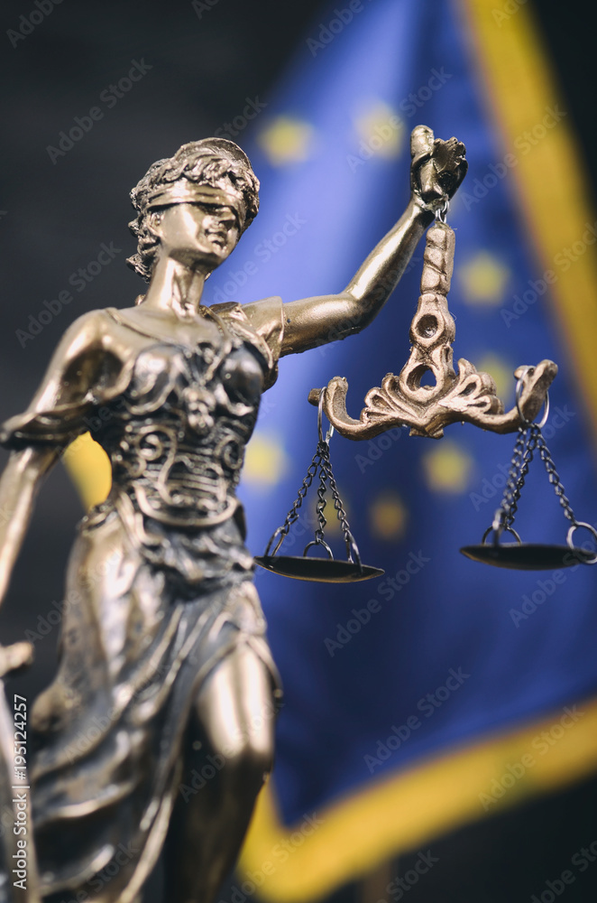 Scales of Justice, Justitia, Lady Justice in front of the European Union flag in the background.