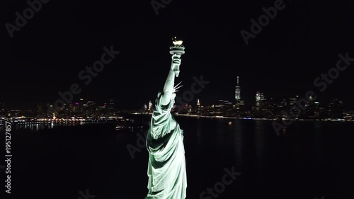 circling aerial shot of Statue of Liberty at night in New York City, NYC in 4K