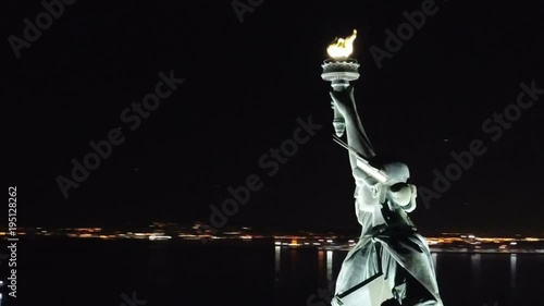 aerial of Statue of Liberty at night with New York City skyline in background - 1080 HD in NYC
