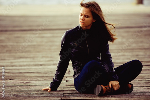 girl in a leather jacket sits outside the rustic style