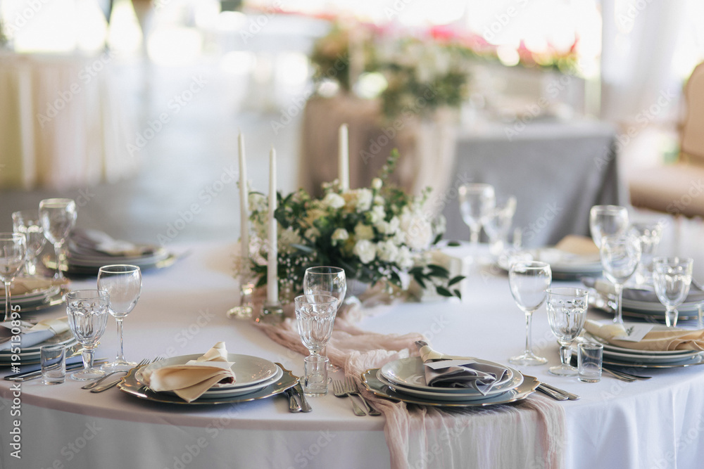 close-up view of beautiful served table with cutlery, flowers and candles at wedding reception