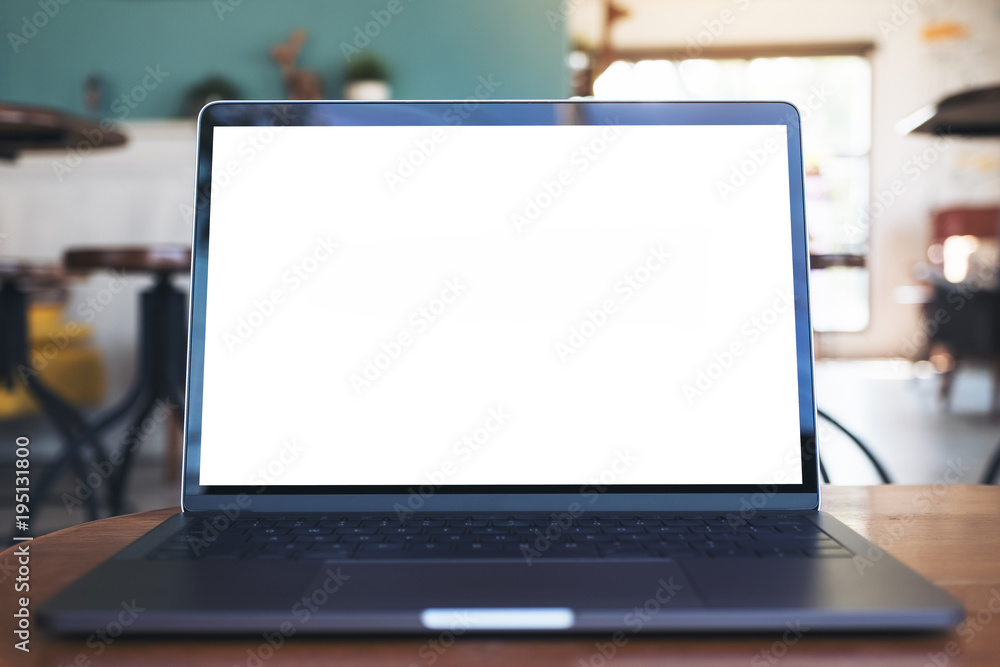 Mockup image of laptop with blank white desktop screen on wooden table in modern cafe Mockup image of laptop with blank white desktop screen on wooden table in modern cafe