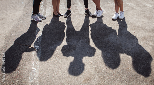 Silhouettes of legs of five standing peoples