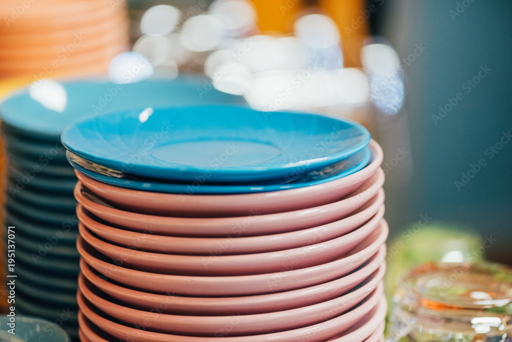 close-up view of stacked clean blue and pink plates in kitchen close-up view of stacked clean blue and pink plates in kitchen