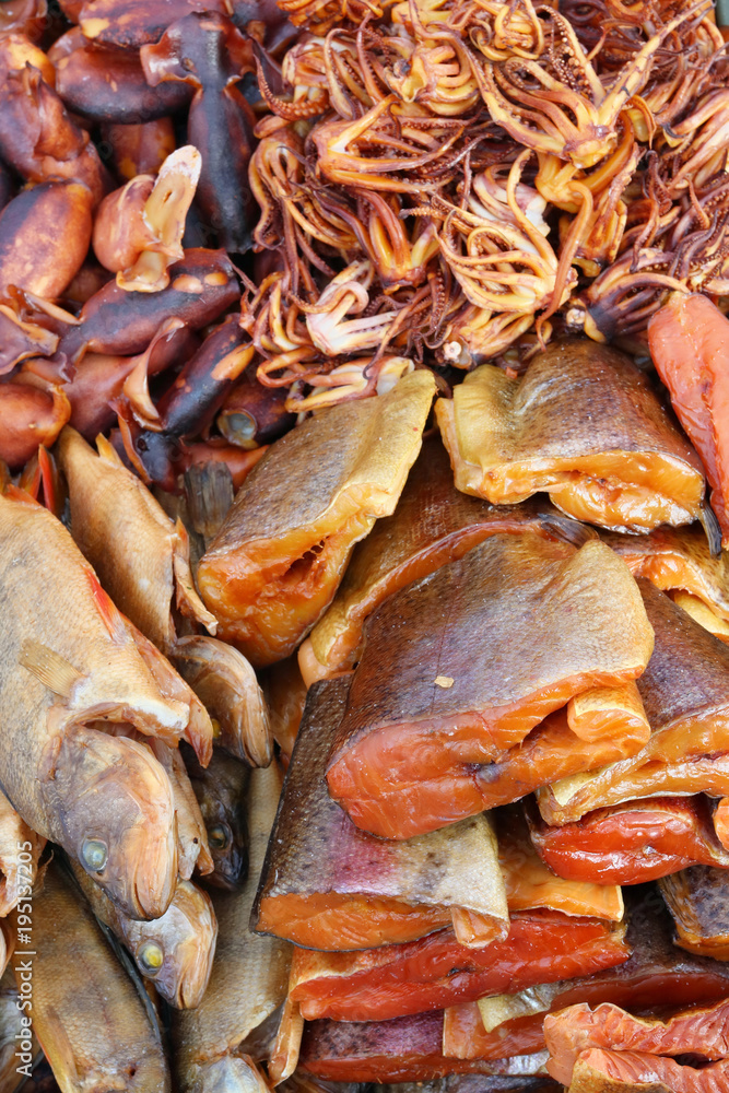 Pieces of grilled smoked salmon fish, squid and octopus with spices and pepper. Pieces of grilled smoked salmon fish, squid and octopus with spices and pepper.