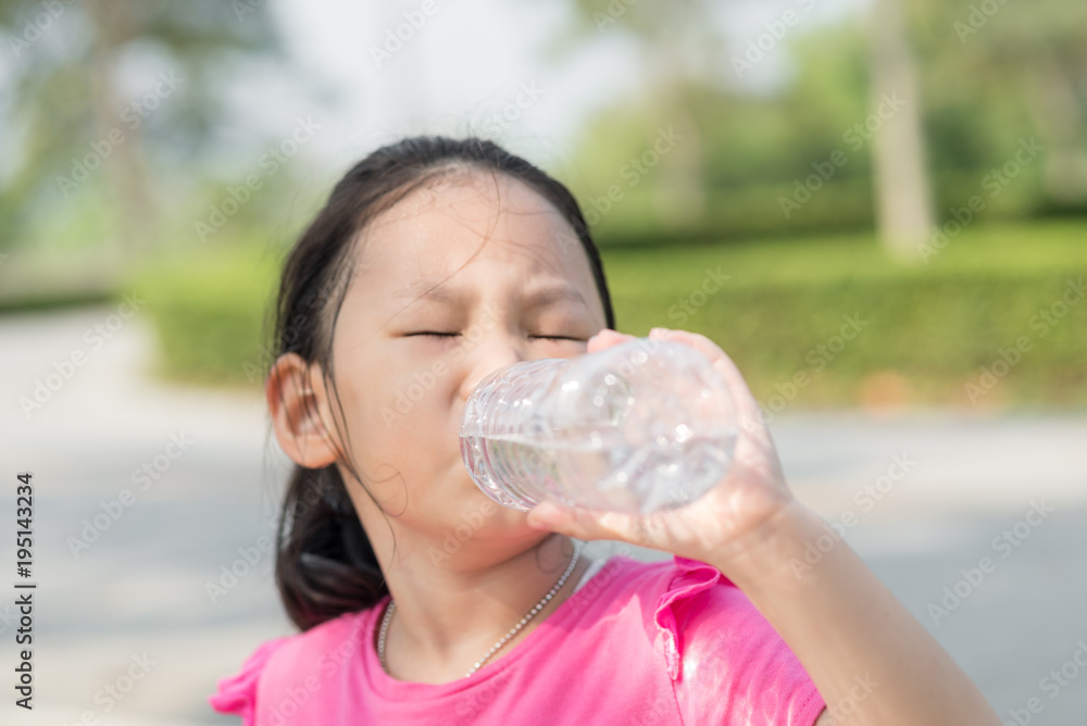 Happy Asian girl drinking a bottle of water outdoor. Happy Asian girl drinking a bottle of water outdoor.