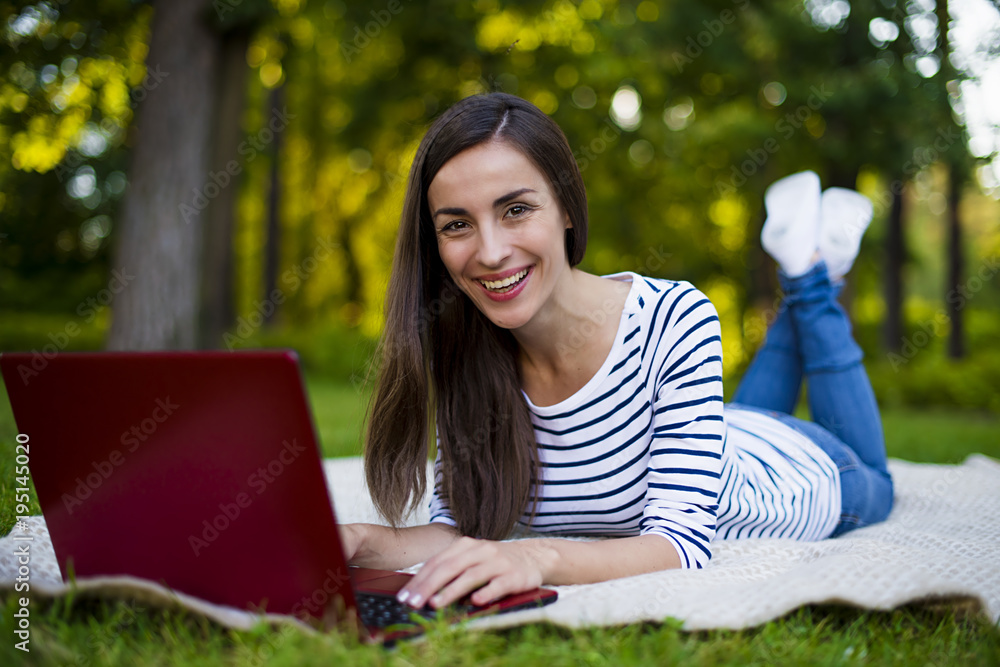 You can work in the fresh air. Smiling young woman looking at camera while working on laptop outdoors You can work in the fresh air. Smiling young woman looking at camera while working on laptop outdoors