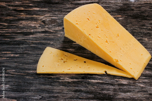 Hard cheese on a wooden table. Dairy products and agriculture. photo