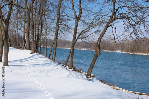 Fototapeta Naklejka Na Ścianę i Meble -  The flowing river on a snowy cold winter day.