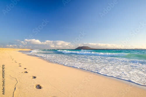 Stunning morning view of the islands of Lobos and Lanzarote seen from Corralejo Beach (Grandes Playas de Corralejo) on Fuerteventura, Canary Islands, Spain, Europe. Beautiful footprints in the sand. photo