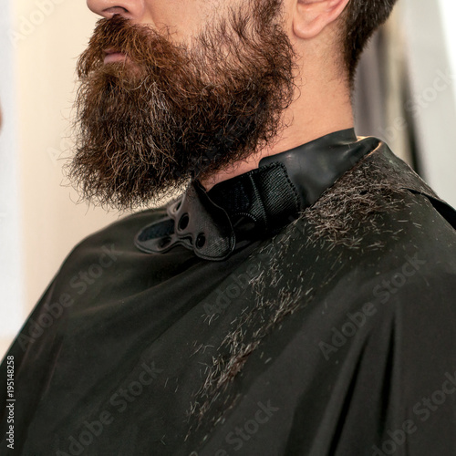 Bearded man in a dressing gown during a haircut photo