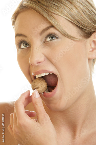 Woman cracking walnut with her teeth