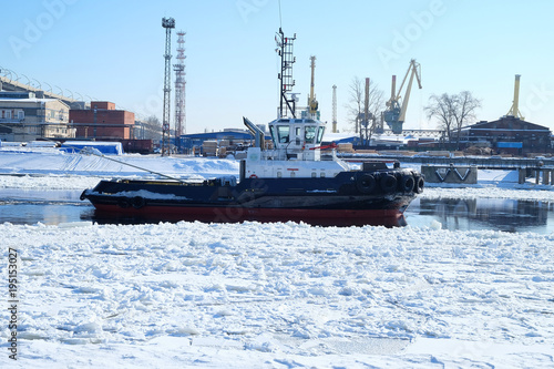 tugboat floats among the ice © sergeevspb