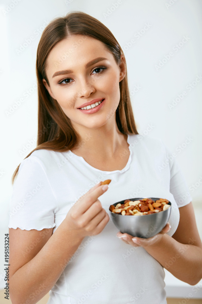 Healthy Food. Happy Woman Eating Nuts Healthy Food. Happy Woman Eating Nuts