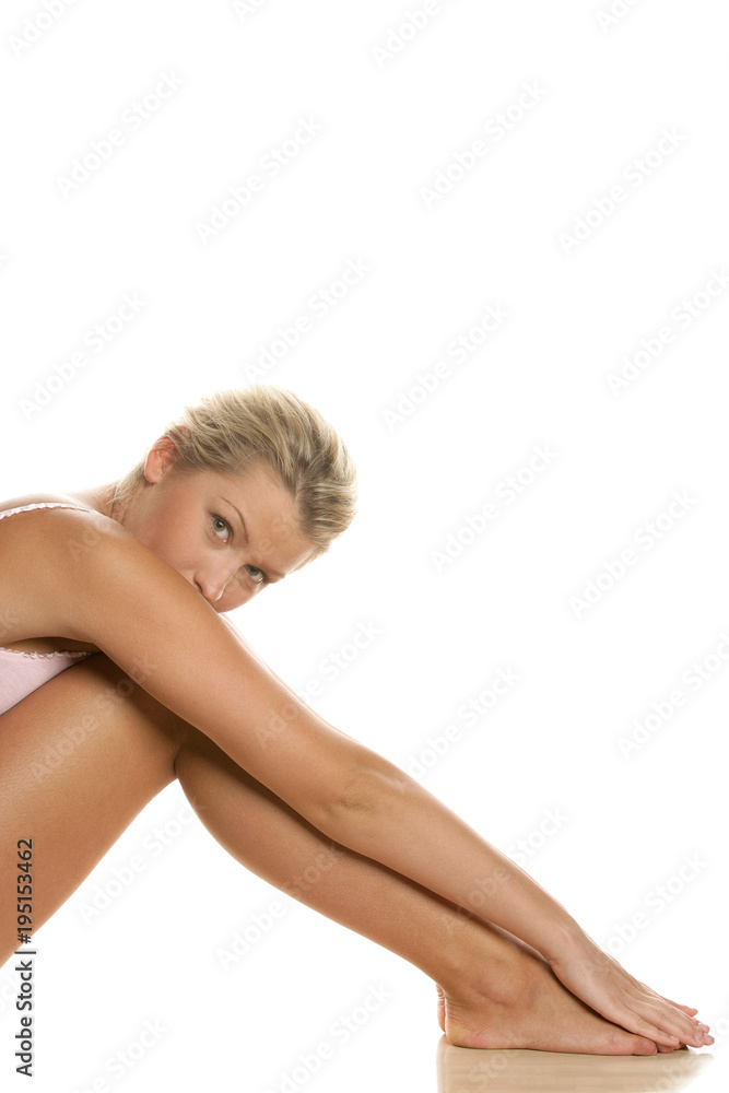 Young beautiful blonde barefoot seminude woman in underwear sitting on the floor Young beautiful blonde barefoot seminude woman in underwear sitting on the floor