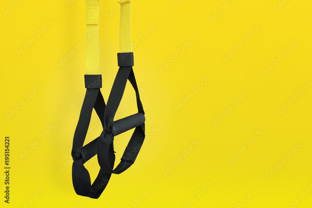 Obraz premium Training loop equipment. Black loop functional training equipment on yellow background. Sport accessories. Fitness and Gym workout items for Healthy.