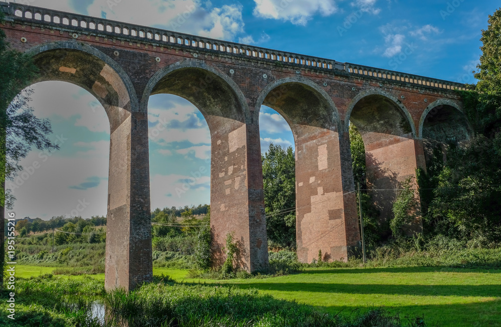 Railway viaduct in Eynesford, Kent with blue sky.  Shot looking up at the brick arches. 
