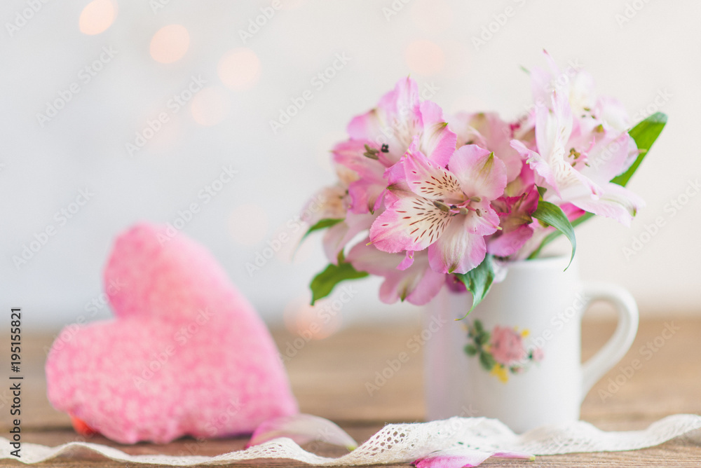 bouquet of flowers in a mug with a plush heart
