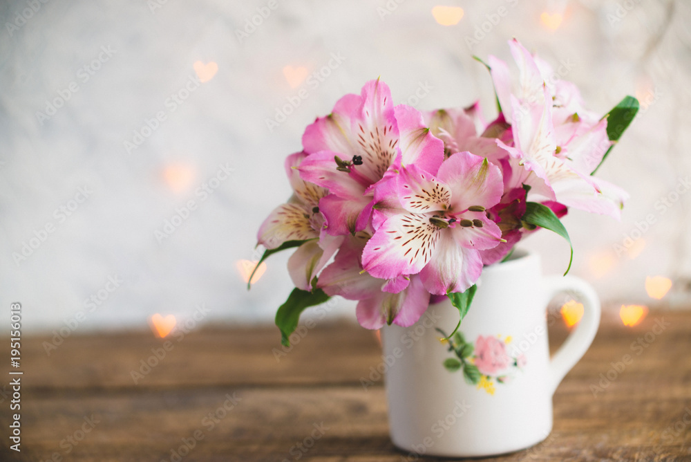 A bouquet of flowers stands in a white mug A bouquet of flowers stands in a white mug